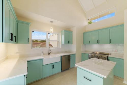a kitchen with mint green cabinets and a window at Casa Colibri in Saint James
