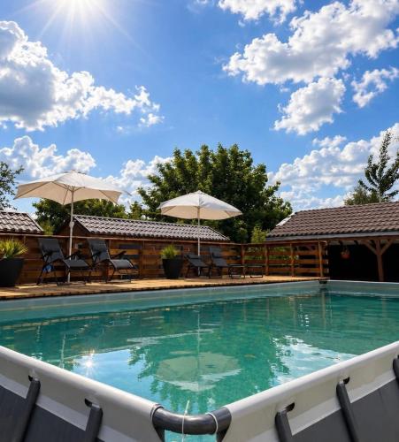 a swimming pool with chairs and umbrellas at Łeba Luxury House in Łeba