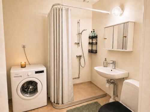 a bathroom with a washing machine and a sink at Klintehamn Rooms - Near the Sea in Klintehamn