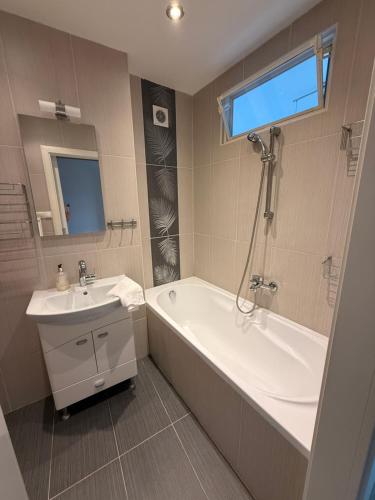 a bathroom with a bath tub and a sink at Apartmán Košice Nad Jazerom in Košice