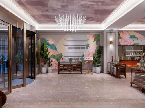 a lobby with a chandelier and a mural on the wall at Mercure Pingyao Ancient City in Pingyao