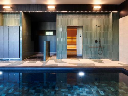 a swimming pool in a building with at Mercure Quimper Kerlic in Quimper