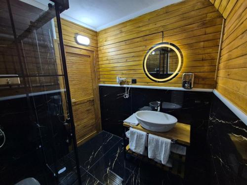 a bathroom with a sink and a shower and a mirror at Yonga Bungalov in Akcaabat