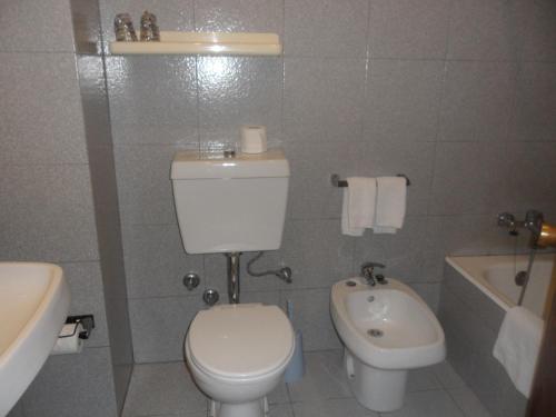 a bathroom with a white toilet and a sink at Hotel Paulista in Porto