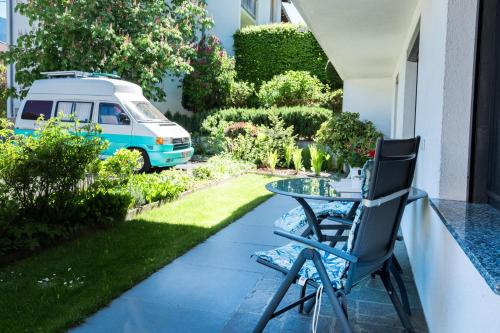 a table and chairs on a porch with a van in the yard at Ferienwohnung Kreidl in Schlitters