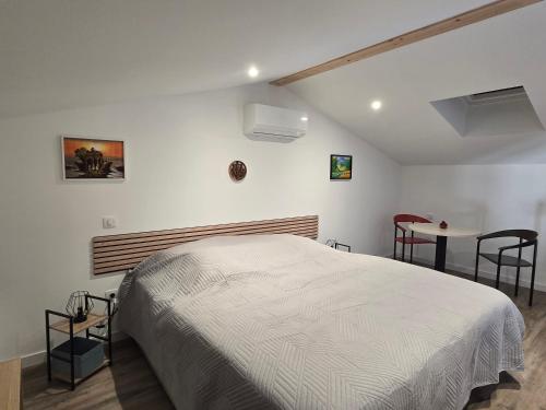 ein Schlafzimmer mit einem weißen Bett und einem Tisch in der Unterkunft Chicken Fields Good ! in Auch