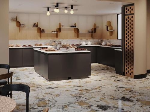 a large kitchen with black cabinets and a marble floor at TRIBE PARIS SURESNES in Suresnes