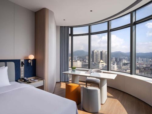 a hotel room with a bed and a desk at NOVOTEL Zhoushan Luting in Zhoushan