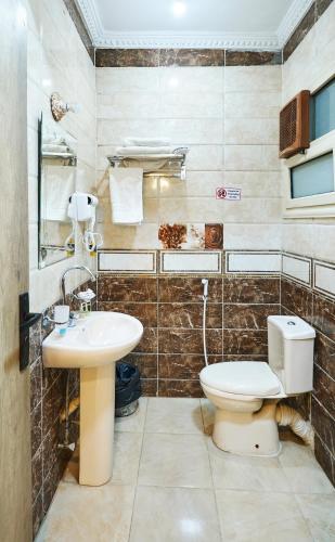 a bathroom with a toilet and a sink at Star View Pyramids Hostel in Nazlet el-Sîsi