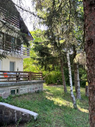 a park with a bench and trees in front of a building at Kuća Sarić, Gružansko jezero in Žune