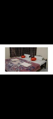 a bedroom with a bed with two red frisbees on it at krishna suraj villa in Chikalda
