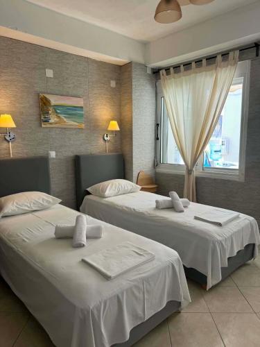 ein Hotelzimmer mit zwei Betten und einem Fenster in der Unterkunft Abeas Samos Antonis 3 in Samos