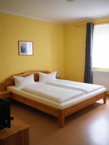 a bedroom with a large bed with white sheets at Pension NoAs in Sassnitz