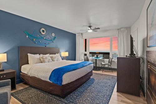 a bedroom with a bed with a blue wall at Sunset Haven Oceanfront Hotel in Depoe Bay