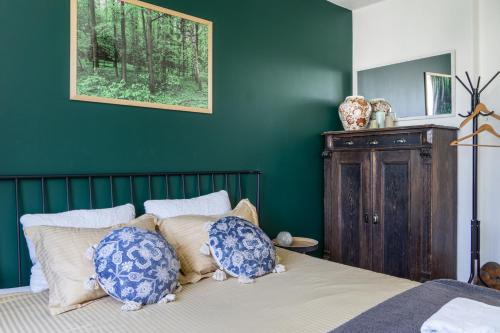a bedroom with green walls and a bed with pillows at Willa Antonina in Supraśl