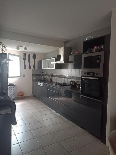 a kitchen with stainless steel appliances and a large kitchen at maison Labenne in Labenne