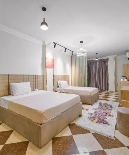 a bedroom with two beds and a rug at Star View Pyramids Hostel in Nazlet el-Sîsi