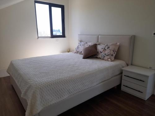 a bedroom with a white bed and a window at Holiday Apartment in Draç