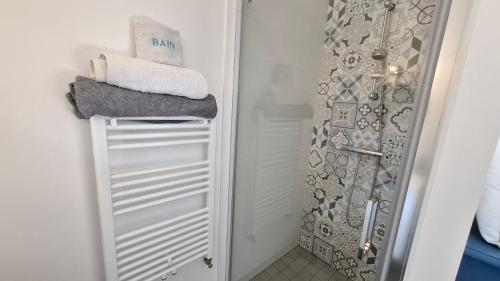 a bathroom with a shower with towels on a shelf at Chambre d'hôtes Nova, petit déjeuner en supplément 5 euros par personne in Saint-Pair-sur-Mer