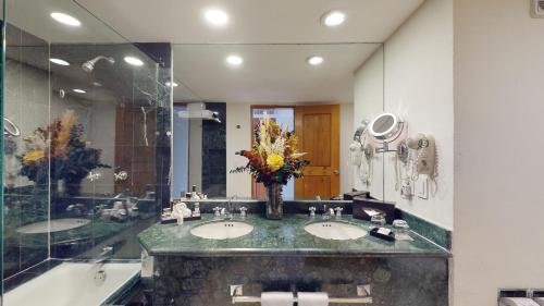 a bathroom with two sinks and a large mirror at The Grand Oasis Cancun - All Inclusive in Cancún