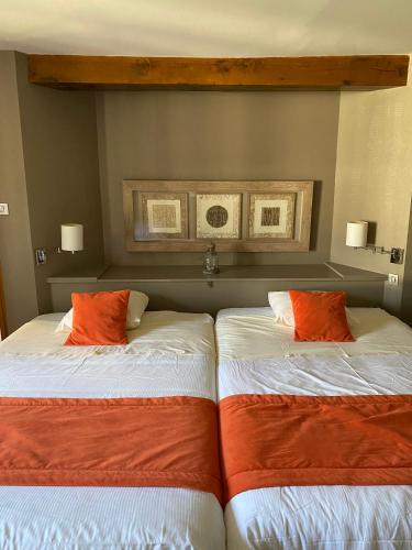 two beds sitting next to each other in a room at Hôtel La Gibecière in Lohéac