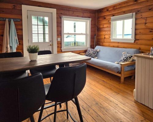 a dining room with a table and a couch at Hunts Point Beach Cottages - Cottage #2 in Summerville Centre