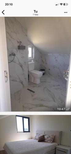a white bathroom with a toilet and a sink at Holiday Apartment in Draç