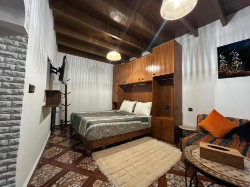 a bedroom with a bed and a couch at Studio ALADIN in Rabat