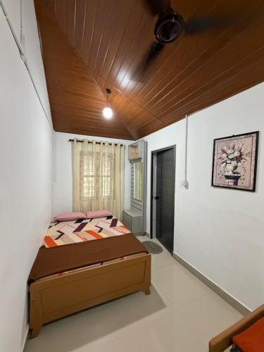 a bedroom with a bed and a wooden ceiling at Koyiloth house by intertrip in Kalpetta