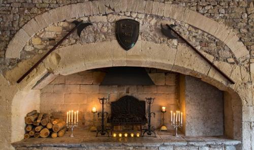 a stone wall with a fireplace with candles in it at Thornbury Castle - A Relais & Chateaux Hotel in Thornbury