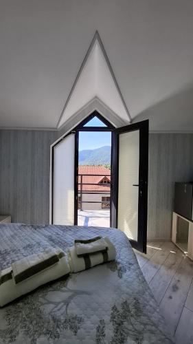 a bedroom with a large bed with a large window at ZemZemHotel in Zaqatala