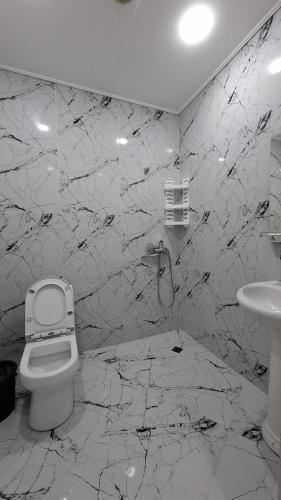 a white bathroom with a toilet and a sink at ZemZemHotel in Zaqatala