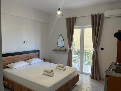 a bedroom with a bed with two towels on it at Riverside Rooms Ammoudia in Ammoudia