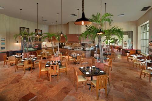 a restaurant with tables and chairs in a room at The Pyramid Cancun by Oasis - All Inclusive in Cancún