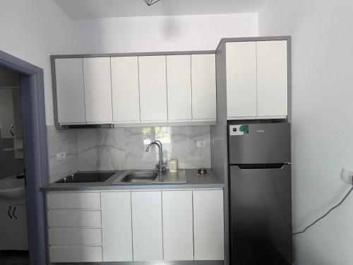 a kitchen with white cabinets and a refrigerator at Hotel Piqeras Kris in Piqeras