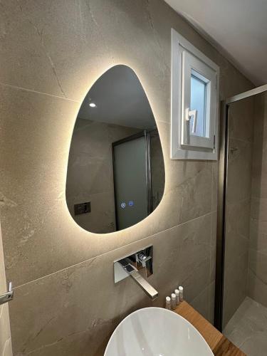 a bathroom with a sink and a mirror at Welcome Naxos in Agios Prokopios