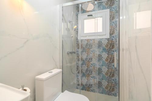 a white bathroom with a shower and a toilet at Sunny Guargacho4 Retreat-South Tenerife in Guargacho