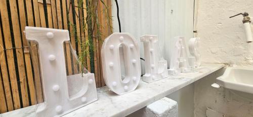 a row of white urinals on a counter next to a sink at Lola's Sanremo Centro in Sanremo