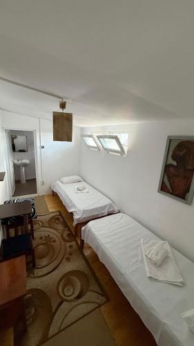 a room with two beds and a rug at Casa Bekirebeki in Vama Veche