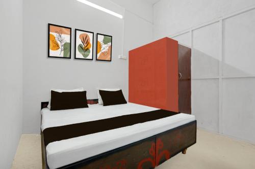 a bedroom with a bed with a red cabinet at SPOT ON Milan Hotel in Hāthras