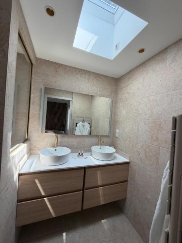 a bathroom with two sinks and a large mirror at Marathi élégance T2 neuf avec SPA privatif in Biscarrosse