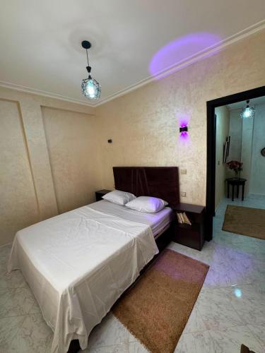 a bedroom with a white bed and a mirror at Cozy two bedroom apartment in Meknès