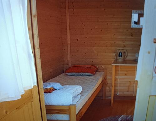 a small room with a bed in a wooden cabin at Kolkja Holiday Centre -Kolkja Puhkeküla in Kolkja