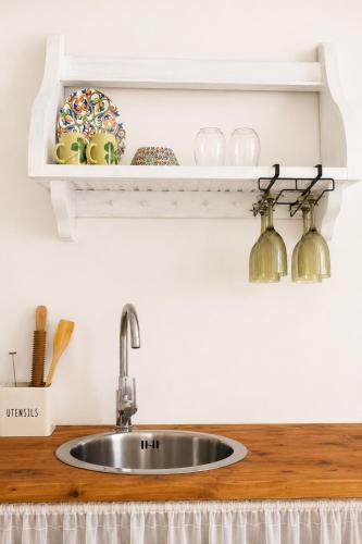 a kitchen counter with a sink and a shelf at Colonna Apartment Ostuni in Ostuni