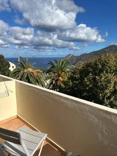 a balcony with a chair and a view of the ocean at Au bon clocher in Canari