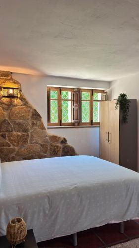 a bedroom with a large bed in a room with windows at Alojamientos del Valle in Sotillo de la Adrada