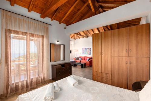 a bedroom with a bed and a tv and a couch at Skiathos Garden Cottages in Skiathos