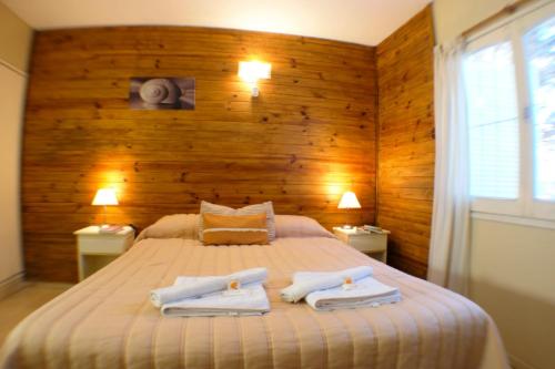 a bedroom with a bed with two towels on it at Kumen Apart de Playa in San Bernardo