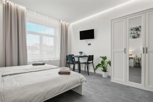a bedroom with a bed and a table with chairs at SPECTRA Rooms in Velké Meziříčí