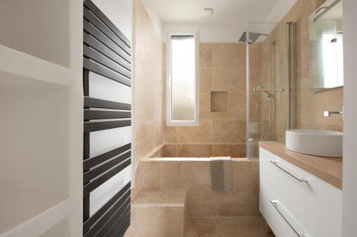 a bathroom with a shower and a sink and a tub at Villa Marius in Albi